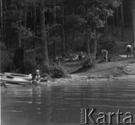 1961 lub 1965, Wigry, woj. białostockie, Polska.
Grupa turystów rozbija obóz namiotowy w lesie nad brzegiem wigierskim.
Fot. Jerzy Konrad Maciejewski, zbiory Ośrodka KARTA