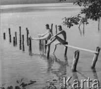 Brak daty, Łagów Lubuski, woj. zielonogórskie, Polska.
Chłopcy siedzą na drewnianej desce nad Jeziorem Trześniowskim. 
Fot. Jerzy Konrad Maciejewski, zbiory Ośrodka KARTA
