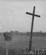 Prawdopodobnie lata 50., Łogów k. Łowicza, woj. łódzkie, Polska.
Kierunkowskaz stoi obok przydrożnego krzyża.
Fot. Jerzy Konrad Maciejewski, zbiory Ośrodka KARTA