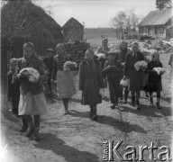 Prawdopodobnie lata 60., Polska.
Grupa dzieci idzie przez wieś, niosąc talerze z żywnością.
Fot. Jerzy Konrad Maciejewski, zbiory Ośrodka KARTA