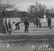 Prawdopodobnie lata 60., Polska.
Chłopcy podczas zabawy. W głębi widoczna jest figura Matki Boskiej.
Fot. Jerzy Konrad Maciejewski, zbiory Ośrodka KARTA