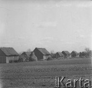 Prawdopodobnie lata 60., Polska.
Zabudowania gospodarskie. Obok budynków stoją stogi siana. 
Fot. Jerzy Konrad Maciejewski, zbiory Ośrodka KARTA