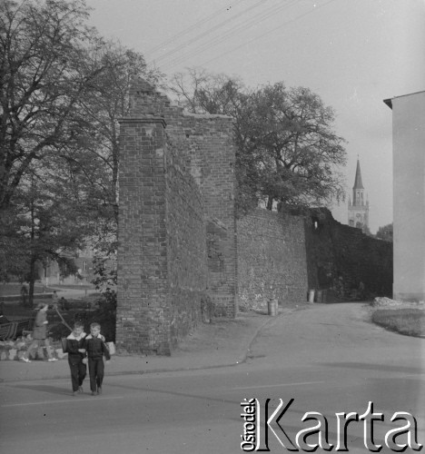 Po 1946, Gorzów Wielkopolski, woj. poznańskie, Polska.
Chłopcy przechodzą obok zachowanego fragmentu murów obronnych z początku XIV wieku. W głębi widoczna wieża kościoła. 
Fot. Jerzy Konrad Maciejewski, zbiory Ośrodka KARTA
