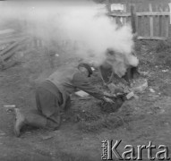 1971, Paszki Małe k. Borek Radzyńskich, woj. lubelskie, Polska.
Stefan Mrówczyński wędzi wędliny na święta wielkanocne w prowizorycznej wędzarni na podwórzu swojego gospodarstwa.
Fot. Jerzy Konrad Maciejewski, zbiory Ośrodka KARTA