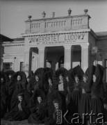 Ok. 1950, Pawłowice k. Sędziszowa, woj. kieleckie, Polska.
Absolwentki ubrane w togi stoją przed budynkiem Uniwersytetu Ludowego, założonego przez Waldemara Babinicza. Działał w latach 1945-1952.  Po wojnie dawny dwór szlachecki rodziny Chwalibogów został zaadoptowany na potrzeby uniwersytetu. 
Fot. Jerzy Konrad Maciejewski, zbiory Ośrodka KARTA