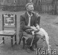 Brak daty, Golanka k. Kadzidła, Polska.
Stanisław Mróz z Kadzidła siedzi na krześle wykonanym przez miejscowego snycerza. Na kolanach trzyma psa.
Fot. Jerzy Konrad Maciejewski, zbiory Ośrodka KARTA