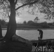 Lata 60. lub 70., Górecko Kościelne, woj. lubelskie, Polska.
Rozlewisko rzeki Szum. Chłopiec na pomoście trzyma w ręku wiadro.
Fot. Jerzy Konrad Maciejewski, zbiory Ośrodka KARTA