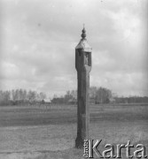 Lata 60. lub 70., Górecko Kościelne, woj. lubelskie, Polska.
Stojąca w polu na drewnianym słupie mała kapliczka.
Fot. Jerzy Konrad Maciejewski, zbiory Ośrodka KARTA