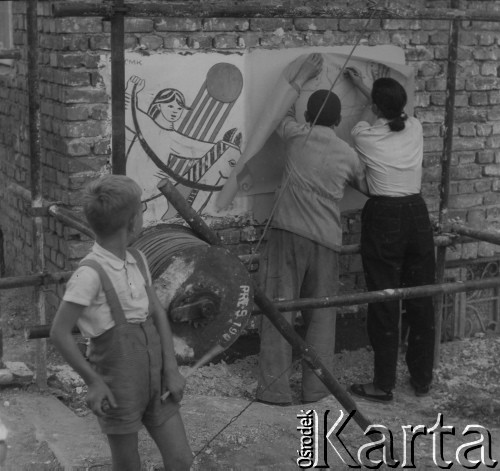 Po 1945, Warszawa, Polska.
Chłopiec patrzy na rysowników, którzy przerysowują na papier malunek na ścianie remontowanego budynku.
Fot. Jerzy Konrad Maciejewski, zbiory Ośrodka KARTA