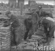 1950, Warszawa, Polska.
Brygada robotników Józefa Czajki ze Społecznego Towarzystwa Budowlanego na Mokotowie pracuje przy budowie domu mieszkalnego. 1. z lewej stoi Marian Czajka, 2. z lewej, pochylony Józef Czajka. Zespół murarski Józefa Czajki ułożył 84.380 sztuk cegieł w ciągu dnia.
Fot. Jerzy Konrad Maciejewski, zbiory Ośrodka KARTA