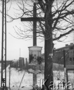 Po 1945, Warszawa, Polska.
Przydrożny krzyż z kapliczką stoi przy zabudowaniach fabrycznych.
Fot. Jerzy Konrad Maciejewski, zbiory Ośrodka KARTA