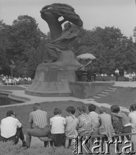 Lato 1964, Warszawa, Polska.
Młodzi słuchacze podczas niedzielnego koncertu chopinowskiego w Łazienkach Królewskich. Na fortepianie gra prof. Stanisław Staniewicz.
Fot. Jerzy Konrad Maciejewski, zbiory Ośrodka KARTA