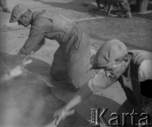 1949, Warszawa, Polska.
Robotnicy przy asfaltowaniu trasy W-Z. 2. z lewej klęczy Józef Krawczyk.
Fot. Jerzy Konrad Maciejewski, zbiory Ośrodka KARTA