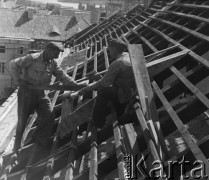 1948, Warszawa, Polska.
Cieśla Piotr Walencik (od lewej) i Edward Cichocki podczas pracy na dachu budowanego budynku.
Fot. Jerzy Konrad Maciejewski, zbiory Ośrodka KARTA