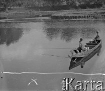 Lata 50. lub 60., Warszawa, Polska.
Prawdopodobnie Jezioro Wilanowskie. Mężczyźni siedzą w łódce i łowią ryby.
Fot. Jerzy Konrad Maciejewski, zbiory Ośrodka KARTA