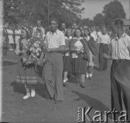Po 1945, Mrozy, woj. warszawskie, Polska.
Mieszkańcy wsi biorą udział w Dożynkach. Na czele pochodu idzie mężczyzna oraz kobieta, którzy trzymają wieniec. Mieszkanki wsi ubrane są w stroje ludowe.
Fot. Jerzy Konrad Maciejewski, zbiory Ośrodka KARTA