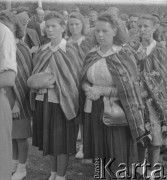 Po 1945, Mrozy, woj. warszawskie, Polska.
Mieszkanki wsi biorą udział w Dożynkach ubrane w stroje ludowe. Jedna z kobiet trzyma upieczony bochenek chleba z nowych plonów.
Fot. Jerzy Konrad Maciejewski, zbiory Ośrodka KARTA
