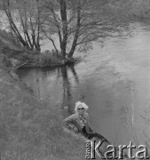 Prawdopodobnie lata 50., prawdopodobnie Konin, woj. poznańskie, Polska.
Kobieta siedzi prawdopodobnie nad brzegiem rzeki Warta. Zdjęcie wykonane przez Jerzego Konrada Maciejewskiego podczas dziennikarskiej wycieczki.
Fot. Jerzy Konrad Maciejewski, zbiory Ośrodka KARTA