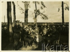 Lata 30., Polska.
Orkiestra batalionu Korpusu Ochrony Pogranicza. Wokół siedzą żołnierze przy stołach na świeżym powietrzu.
Fot. Konrad Jerzy Maciejewski, zbiory Ośrodka KARTA