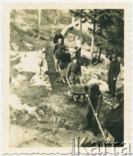 Po 1943, Neunhof, Szwajcaria.
Internowani żołnierze z 2. Dywizji Strzelców Pieszych podczas pracy przy budowie drogi w górach. Na zdjęciu część żołnierzy wywozi na taczkach ziemię. W obozie przebywali w latach 1943-1945. W trakcie pobytu byli zobowiązani do pracy w różnych gałęziach szwajcarskiej gospodarki. 
Fot. Jerzy Konrad Maciejewski, zbiory Ośrodka KARTA