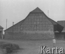 Czerwiec 1940, Saint-Loup-sur-Semouse, Francja.
Kobieta stoi przed murowanym budynkiem.
Fot. Jerzy Konrad Maciejewski, zbiory Ośrodka KARTA