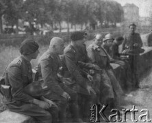 Czerwiec 1940, Saint-Loup-sur-Semouse, Francja.
Kampania francuska. Żołnierze 5 Małopolskiego Pułku Strzelców Pieszych 2. Dywizji Strzelców Pieszych siedzą na murku, czekając na wieści z frontu. 4. z lewej siedzi dowódca 5 Małopolskiego PSP ppłk Bronisław Kowalczewski.
Fot. Jerzy Konrad Maciejewski, zbiory Ośrodka KARTA