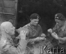 Czerwiec 1940, przed Montbéliard, Francja.
Żołnierze 5 Małopolskiego Pułku Strzelców Pieszych 2. Dywizji Strzelców Pieszych posilają się, siedząc przed wejściem do wagonu. 1. z lewej stoi adiutant dowódcy 5 Małopolskiego PSP kpt. Namysłowski (?).
Fot. Jerzy Konrad Maciejewski, zbiory Ośrodka KARTA