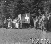 Lato 1940, Weier im Emmental, Szwajcaria.
Ksiądz wygłasza kazanie podczas mszy polowej zorganizowanej dla internowanych żołnierzy 2. Dywizji Strzelców Pieszych. Na zdjęciu widoczny ołtarz na tle flag polskiej i szwajcarskiej.
Fot. Jerzy Konrad Maciejewski, zbiory Ośrodka KARTA