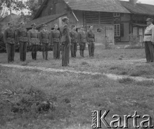 1942-1944, Münchenbuchsee, Szwajcaria.
Żołnierze 4 plutonu 1 kompanii ckm 1 batalionu 4 Warszawskiego Pułku Strzelców Pieszych 2. Dywizji Strzelców Pieszych zdają raport przed swoim dowódcą ppor. Witoldem Cieślą (1. z prawej, w białej górnej części munduru). 
Fot. Jerzy Konrad Maciejewski, zbiory Ośrodka KARTA
