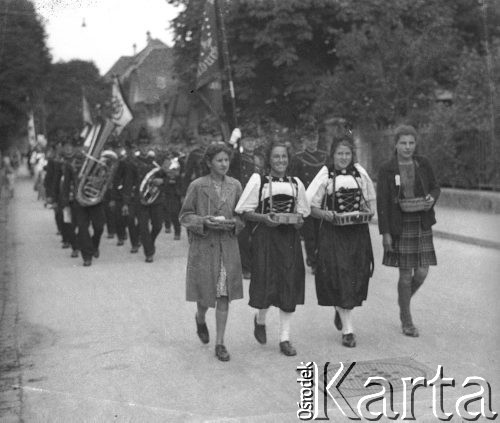 1942-1944, Münchenbuchsee, Szwajcaria.
Uroczysty pochód, na czele którego idą kobiety ubrane w stroje ludowe. Za nimi podąża orkiestra.
Fot. Jerzy Konrad Maciejewski, zbiory Ośrodka KARTA 
