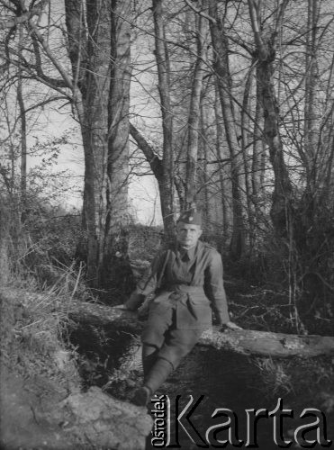 Wiosna 1940, La Maucarriere, Francja.
Sierż. Jerzy Konrad Maciejewski pozuje do zdjęcia siedząc na połamanym drzewie, przerzuconym nad strumieniem.
Fot. NN, kolekcja Jerzego Konrada Maciejewskiego, zbiory Ośrodka KARTA
