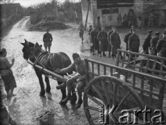 Po 26.01.1940, Thénezay, Francja.
Podwórze, na którym stacjonują oddziały 2. Dywizji Strzelców Pieszych. Na zdjęciu część wojskowych stoi w kolejce po obiad. Na pierwszym planie widać żołnierza siedzącego na wozie zaprzęgniętym w konia.
Fot. Jerzy Konrad Maciejewski, zbiory Ośrodka KARTA