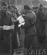 1945-1946, Lys-lez-Lannoy, Francja.
Żołnierz z 2. Dywizji Strzelców Pieszych rozdaje kartki. Jeden z wojskowych czyta jej treść.
Fot. Jerzy Konrad Maciejewski, zbiory Ośrodka KARTA
