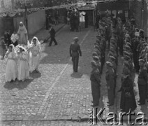 1946, Lys-lez-Lannoy, Francja.
Żołnierze 2. Dywizji Strzelców Pieszych przygotowują się do wzięcia udziału w procesji Bożego Ciała. Obok przechodzą kobiety, które niosą figurę Matki Bożej.
Fot. Jerzy Konrad Maciejewski, zbiory Ośrodka KARTA

