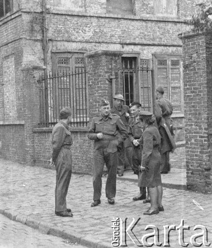 1945, Lys-lez-Lannoy, Francja.
Żołnierze 2. Dywizji Strzelców Pieszych rozmawiają z ochotniczką z Pomocniczej Służby Kobiet przed wejściem na teren obozu.
Fot. Jerzy Konrad Maciejewski, zbiory Ośrodka KARTA
