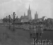 14.04.1946, Ypres, Belgia.
Wojskowy cmentarz angielski, na którym pochowano ofiary z I wojny światowej. Stoją od lewej: NN, Therèse, Bernadette, NN. W głębi widać katedrę St. Martin.  
Fot. Jerzy Konrad Maciejewski, zbiory Ośrodka KARTA