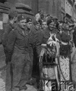 3.05.1946, Lille, Francja.
Rocznica uchwalenia Konstytucji 3 maja. Dziewczynki w strojach ludowych przypinają ozdoby do mundurów żołnierzy polskich.
Fot. Jerzy Konrad Maciejewski, zbiory Ośrodka KARTA