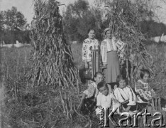 Po październiku 1939, Ocnita, Rumunia.
Rumunki i dzieci ubrane w stroje ludowe pozują do zdjęcia na tle kukurydzy.
Fot. Jerzy Konrad Maciejewski, zbiory Ośrodka KARTA