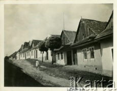 Lata 30., Lewocza, Słowacja.
Domy małomiasteczkowe ustawione wzdłuż drogi, po której idzie dziewczynka.
Fot. Jerzy Konrad Maciejewski, zbiory Ośrodka KARTA