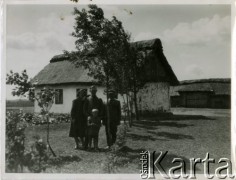 Lata 30., Łosiatyn k. Poczajewa, woj. wołyńskie, Polska.
Osadnik wojskowy z rodziną pozuje do zdjęcia na tle gospodarstwa wiejskiego.
Fot. Jerzy Konrad Maciejewski, zbiory Ośrodka KARTA