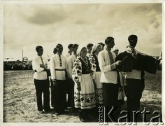 Prawdopodobnie wrzesień 1934, Równe, woj. wołyńskie, Polska.
Młodzież ukraińska w strojach ludowych podczas dożynek otwierających Targi Wołyńskie. Dwóch młodych mężczyzn stojących na początku grupy gra na instrumentach.
Fot. Jerzy Konrad Maciejewski, zbiory Ośrodka KARTA
