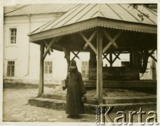 Lata 30., Poczajów, woj. wołyńskie, Polska.
Mnich stoi przy studni, która znajduje się dziedzińcu Ławry Zaśnięcia Matki Bożej - największego klasztoru prawosławnego na Wołyniu. 
Fot. Jerzy Konrad Maciejewski, zbiory Ośrodka KARTA