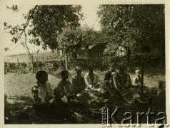 Lata 30., Polanka, woj. lwowskie, Polska.
Kobiety ubrane w stroje ludowe odpoczywają, siedząc w ogrodzie.
Fot. Jerzy Konrad Maciejewski, zbiory Ośrodka KARTA
