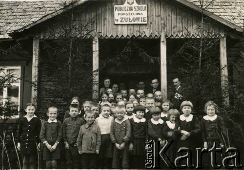 Przed 1939, Zułów, woj. wileńskie, Polska.
Uczniowie i nauczyciele przed budynkiem szkoły powszechnej w Zułowie im. Marii z Billewiczów Piłsudskiej. Dawniej - budynek służby dworskiej w majątku Piłsudskich.
Fot. NN, zbiory Ośrodka KARTA, udostępniła Anna Kiljan