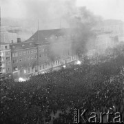 17.12.1970, Szczecin, Polska.
Wydarzenia grudniowe - tłum przed gmachem KW PZPR przy pl. Żołnierza Polskiego, róg ul. Tkackiej.  Na chodniku płoną dokumenty i wyposażenie wyrzucane przez okna z gmachu Domu Partii.
Fot. Maciej Jasiecki, zbiory Ośrodka KARTA