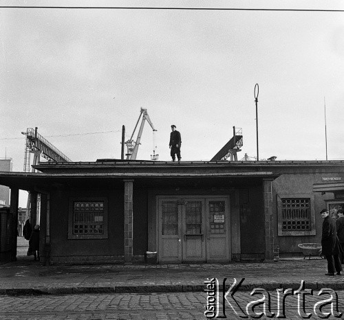14-22.12.1970, Szczecin, Polska.
Wydarzenia grudniowe - ul. Tomasza Nocznickiego, brama wejściowa na teren Stoczni Szczecińskiej im. Adolfa Warskiego. Strażnik przemysłowy demontuje hasła strajkowe. 
Fot. Maciej Jasiecki, zbiory Ośrodka KARTA