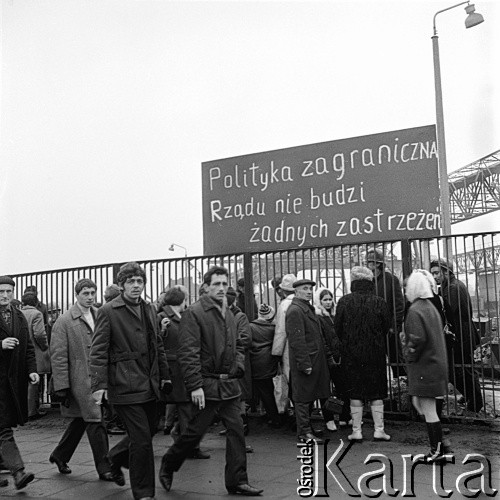 24.01.1971, Szczecin, Polska.
Wydarzenia grudniowe - ul. Tomasza Nocznickiego, ludzie przy Stoczni Szczecińskiej im. Adolfa Warskiego. Nad nimi tablica z napisem: 