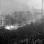 17.12.1970, Szczecin, Polska.
Wydarzenia grudniowe - pl. Żołnierza Polskiego, tłum przed gmachem KW PZPR, płoną dokumenty i meble wyrzucane z budynku. Na dachu redakcji organu partii - „Głosu Szczecińskiego (z prawej) fotoreporter CAF – Andrzej Wituszyński. Moment nieudanego szturmu milicji próbującej odepchnąć demonstrantów spod gmachu. 
Fot. Maciej Jasiecki, zbiory Ośrodka KARTA