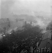 17.12.1970, Szczecin, Polska.
Wydarzenia grudniowe - pl. Żołnierza Polskiego, tłum przed gmachem KW PZPR, płoną dokumenty i meble wyrzucane z budynku. Na dachu redakcji organu partii - „Głosu Szczecińskiego (z prawej) fotoreporter CAF – Andrzej Wituszyński. Moment nieudanego szturmu milicji próbującej odepchnąć demonstrantów spod gmachu. 
Fot. Maciej Jasiecki, zbiory Ośrodka KARTA