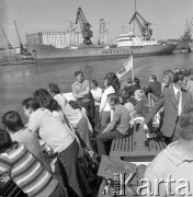 Lata 70., Szczecin, Polska.
Wycieczka rejsem „białej floty” po porcie szczecińskim. W tle M/S „Radom” armatora „Uniafrica”. Za nim budynek chłodni przedsiębiorstwa połowów dalekomorskich„Dalmor”.
Fot. Maciej Jasiecki, zbiory Ośrodka KARTA